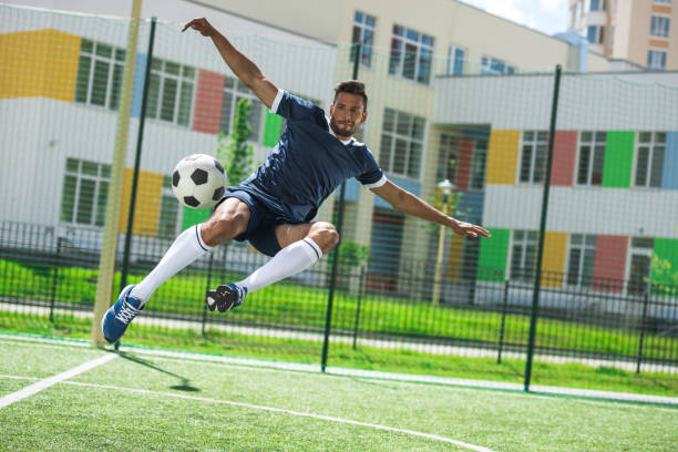 istock athletic soccer player kicking ball on soccer pitch during match 812997670