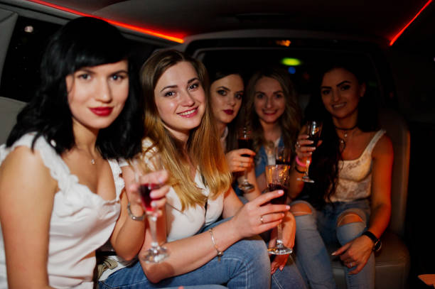 istock Gorgeous girls having fun and drinking while sitting inside the luxurious limousin at bachelorette party. 813001258