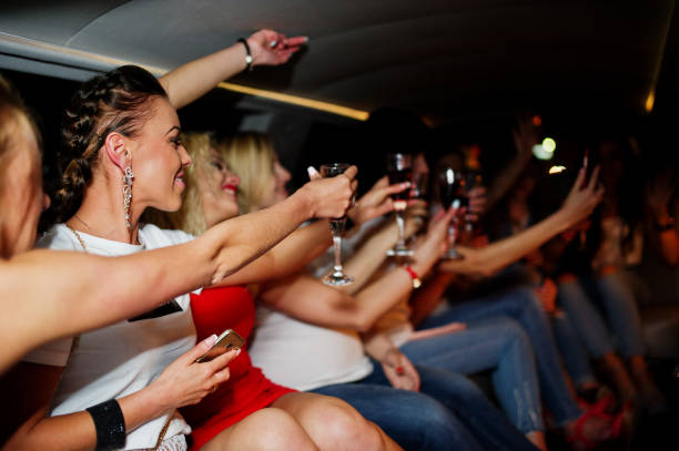 istock Gorgeous girls having fun and drinking while sitting inside the luxurious limousin at bachelorette party. 813001290