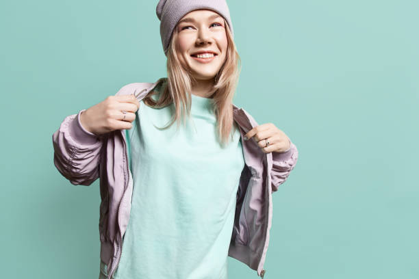fashion young woman in blank sweatshirt jacket takes on a blue background in pastel colors - t shirt shirt pink blank imagens e fotografias de stock