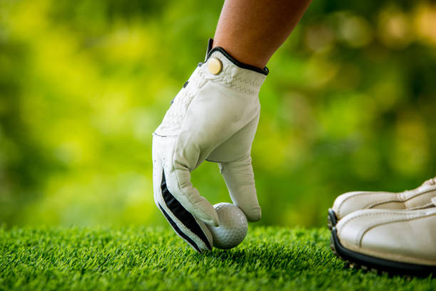 istock golf players hand placing ball on grass 813011990