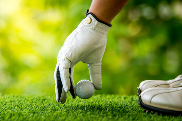 istock golf players hand placing ball on grass 813011994