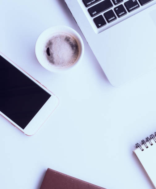 istock Top view of white office table with laptop and smartphone . Top view with copy space. 813012886