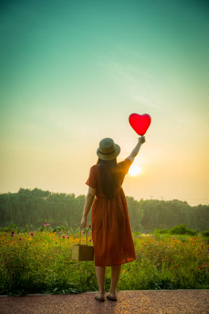 istock Young woman holding heart-shaped balloon 813016290