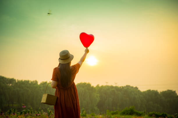 istock Young woman holding heart-shaped balloon 813016324