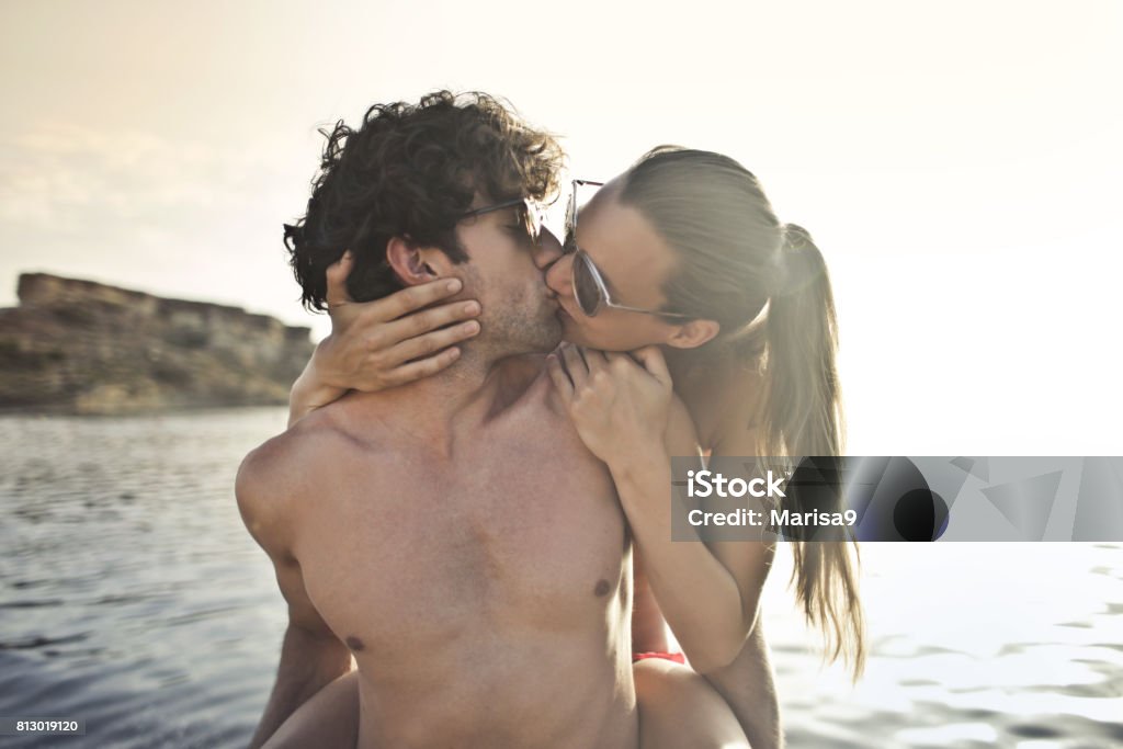 Passionate kiss Couple of young lovers kissing at the seaside Couple - Relationship Stock Photo