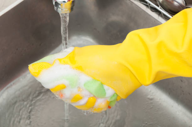 istock Hand with glove holding sponge full of foam 813019710
