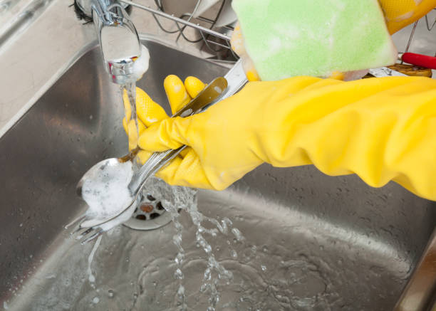 istock Woman hands rinsing cutlery under running water 813019928