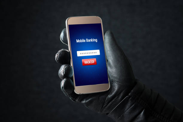 istock Mobile banking hack and cyber security concept. Hacker and criminal login to persons online bank application and steal money from account with smartphone. Thief with black leather gloves. 813024736