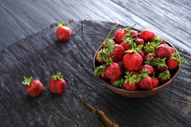 istock Red fresh strawberries on black rustic wood background 813038216