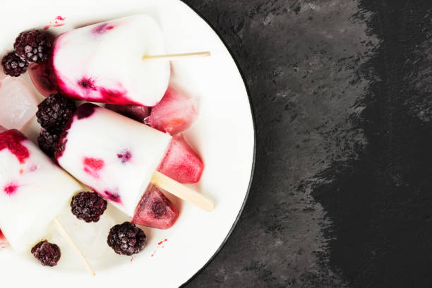 istock Ice cream from yogurt / coconut milk with blackberry and raspberry on a dark background. Top view, copy space. Food background 813044742