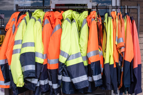 Protective clothing on rack Full frame view of yellow and orange high visibiity protective clothing on rack protective workwear stock pictures, royalty-free photos & images