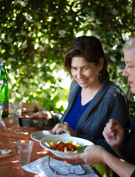 istock Italy: Female Senior Friends Share Lunch Under Jasmine 813085584
