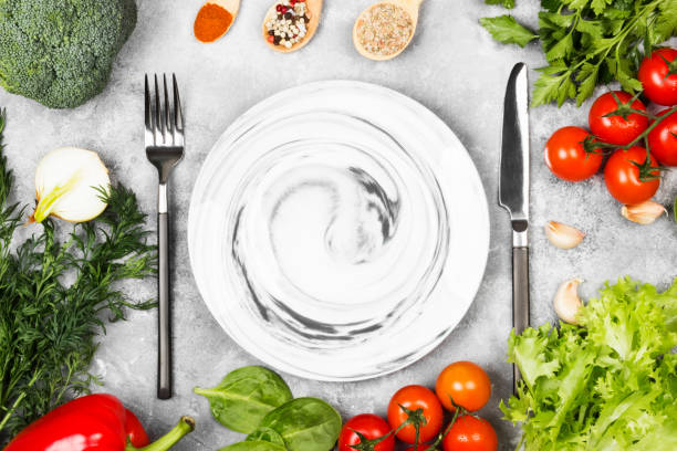 istock Concept dietary and vegetable food. Plate with marble patterns. Various vegetables and spices (broccoli, pepper, cherry tomatoes, garlic, lettuce, parsley, fennel) on a light background. Top view, copy space. Food background 813086642
