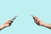 Two hands holding mobile phones