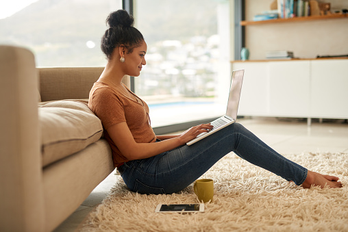 Shot of a young woman using a laptop at home