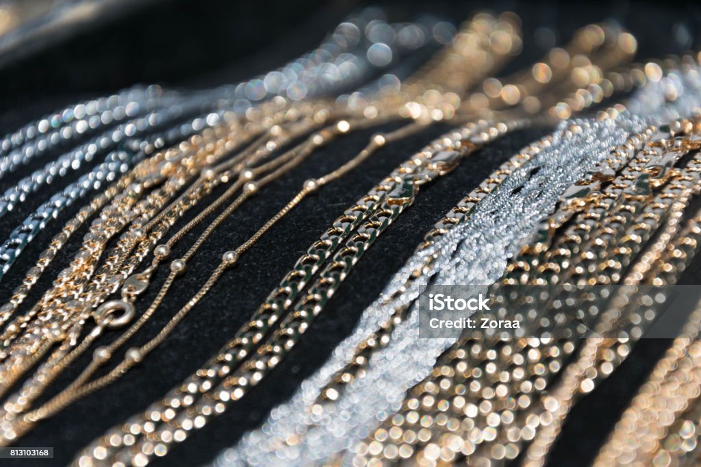 silver and gold necklaces and bracelets lying on black background Jewelry Stock Photo