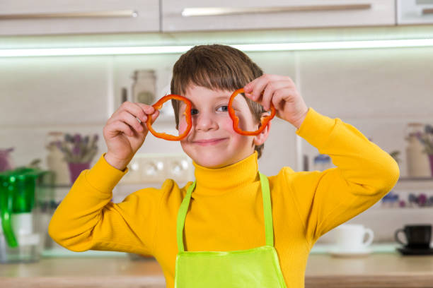 istock Funny boy with sliced paprika on eyes 813114954