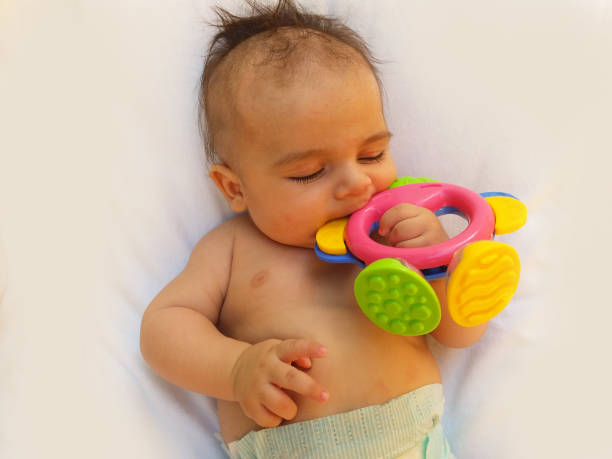 istock 3 months old baby boy playing with teething toy 813118134