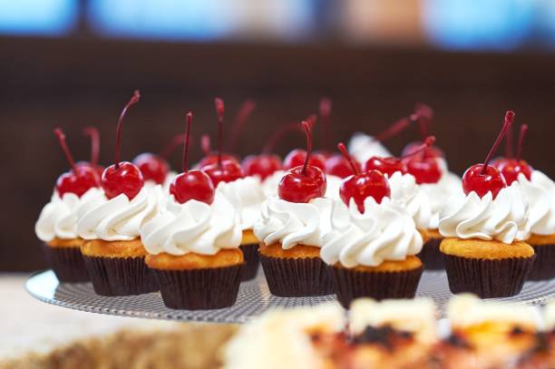 istock Plate full of cupcakes with cream and cherry on top 813136206