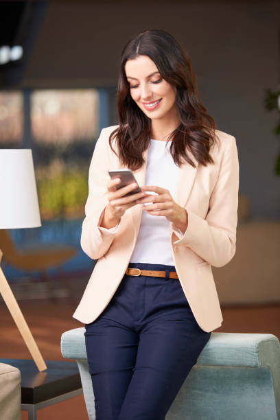 mujer feliz con su cellpone - women computer home interior brown hair fotografías e imágenes de stock