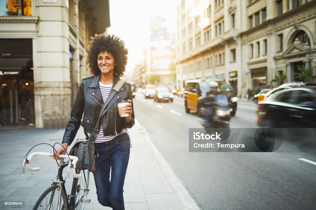 Young hipster woman in the streets of Barcelona commuting. Young hipster woman in the streets of Barcelona commuting. Mixed race model, spanish and Ethiopian. Women Stock Photo