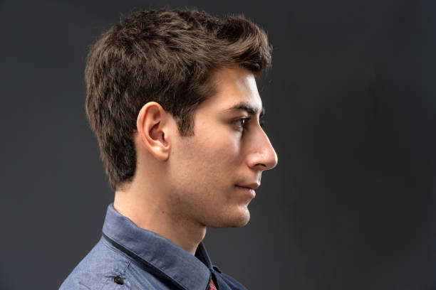 Serious young man profile of serious hispanic or middle eastern young man looking at the camera profile view photos stock pictures, royalty-free photos & images