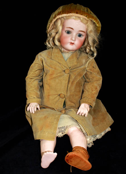 istock Antique Toy Doll on Black Background Missing a Shoe 813146144