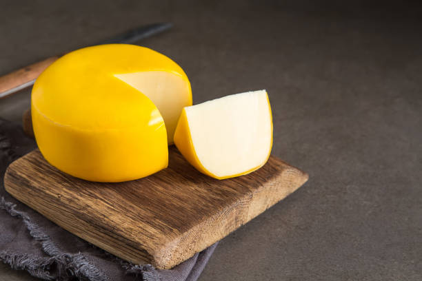 round gouda cheese. dark background. - gouda imagens e fotografias de stock