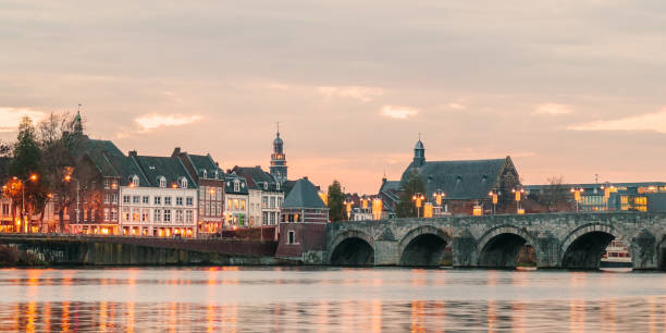 blick auf die niederländischen sint servaas brücke mit lichtern in maastricht - christmas sunset house residential structure stock-fotos und bilder