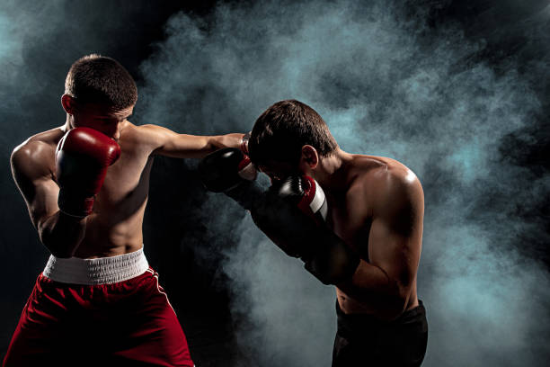 istock Two professional boxer boxing on black smoky background 813176396