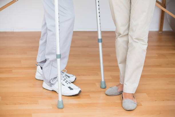 istock Doctor helping her patient walking with crutch 813176464