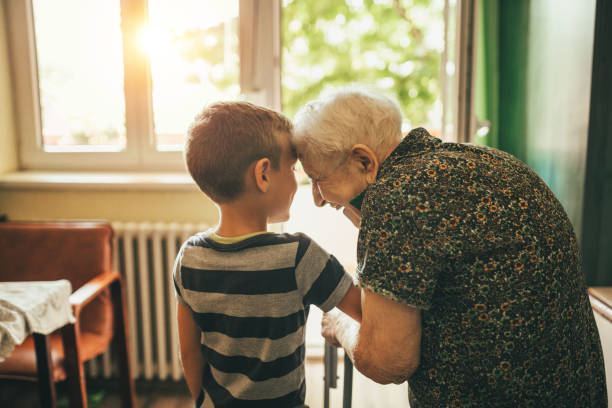 nieto a su abuela en vivero - grandson fotografías e imágenes de stock