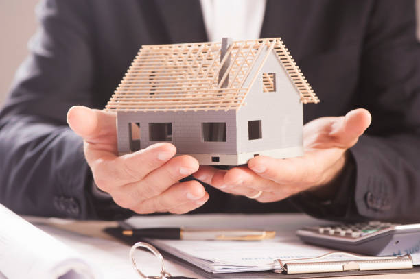istock Real estate agent holding house model 813187176