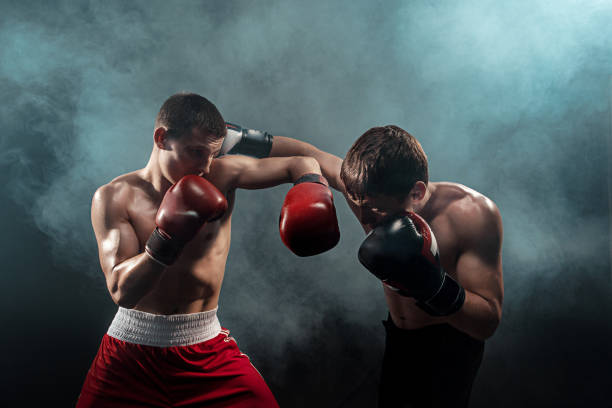 zwei profi-boxer boxen auf schwarzem hintergrund rauchige - kämpfen fotos stock-fotos und bilder