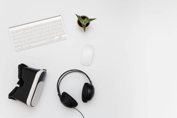istock Desk with virtual reality device, heaphones, keyboard mouse and a fat plant 813195524
