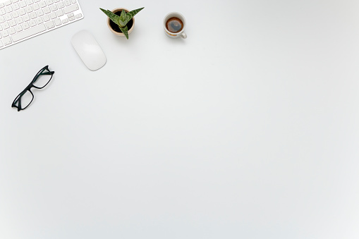 Amplio escritorio con gafas, teclado, ratón, café y grasa vegetal photo