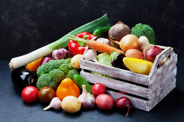 istock Wooden box with autumn harvest farm vegetables and root crops on black kitchen table. 813195968