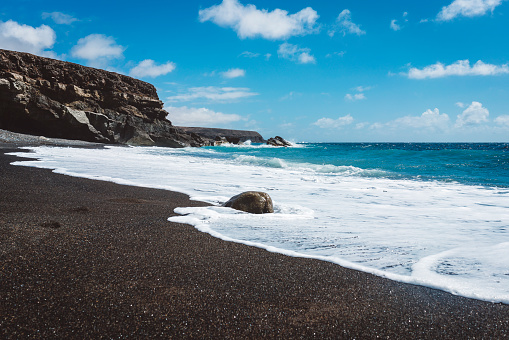Black sand beach on a sunny day, summertime, vacations and travel, travel destinations in Europe, Canary Islands