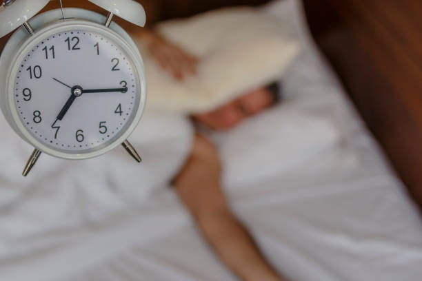istock Young man lying in bed suffering from alarm 813199156