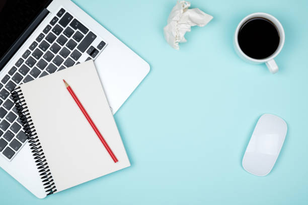 istock Minimal workplace with laptop and blank notepad on colored background. Top view. Flat lay 813202946