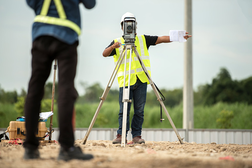 survey engineer in construction site use theodolite mark a concrete pile co ordinate