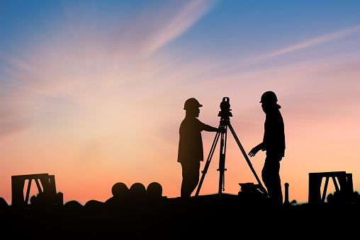 silhouette survey engineer in construction site use theodolite mark a concrete pile co ordinate