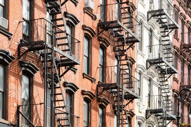 New York City style apartment buildings exterior view with windows and fire escapes