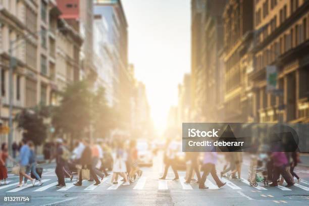 Anonyme Gruppe Von Menschen Zu Fuß Über Eine Fußgängerzone Zebrastreifen Auf Einer Newyorkcitystraße Mit Einem Glühenden Sonnenuntergang Licht Im Hintergrund Stockfoto und mehr Bilder von Menschen