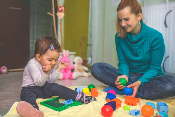 istock Mother and daughter playing on the floor 813225458