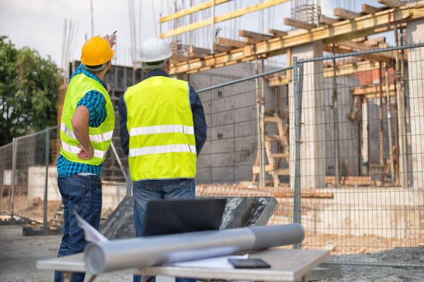 istock Men in hardhat and green jacket posing on building site 813227764
