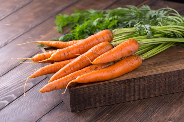 istock fresh carrots bunch on rustic wooden background 813253406