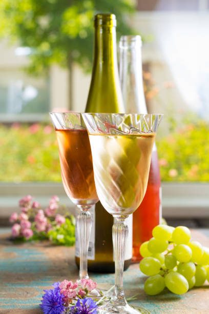 vins d’été froide, blanc et rose, servi dans beaux verres sur l’air pur, en plein air dans le jardin avec des fleurs, journée ensoleillée - chardonnay grape focus on foreground france western europe photos et images de collection