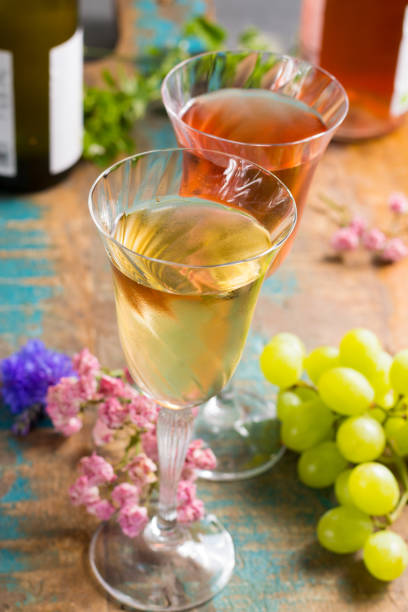 vins d’été froide, blanches et roses, servi dans beaux verres sur la terrasse de café avec fleurs romantiques - chardonnay grape focus on foreground france western europe photos et images de collection